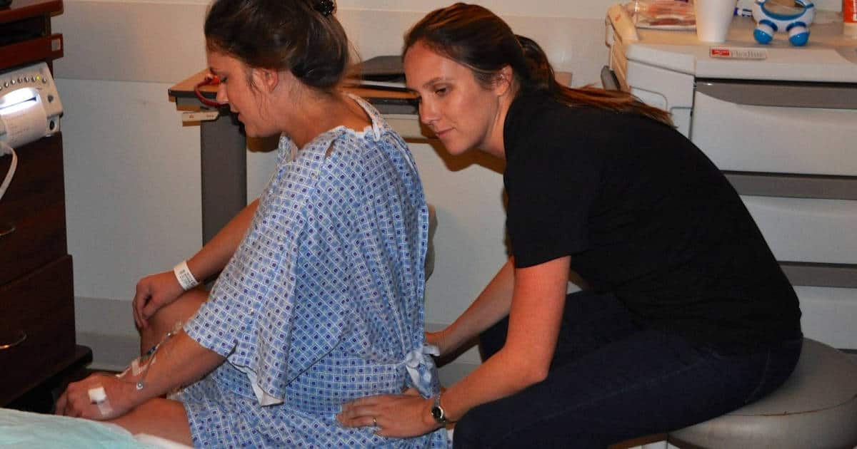 Buddha Belly Doula providing back massage at hospital birth in Tampa, FL