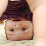 baby playing with bum in air