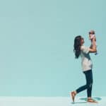 new mom holding baby walking