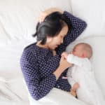 new mom breastfeeding in bed