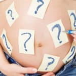 pregnant woman with question mark post its on belly