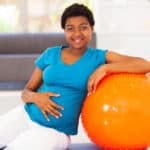 pregnant woman leaning on yoga ball
