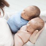 newborn swaddled twin babies with mother
