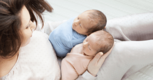 newborn twin babies with mother nursery setup