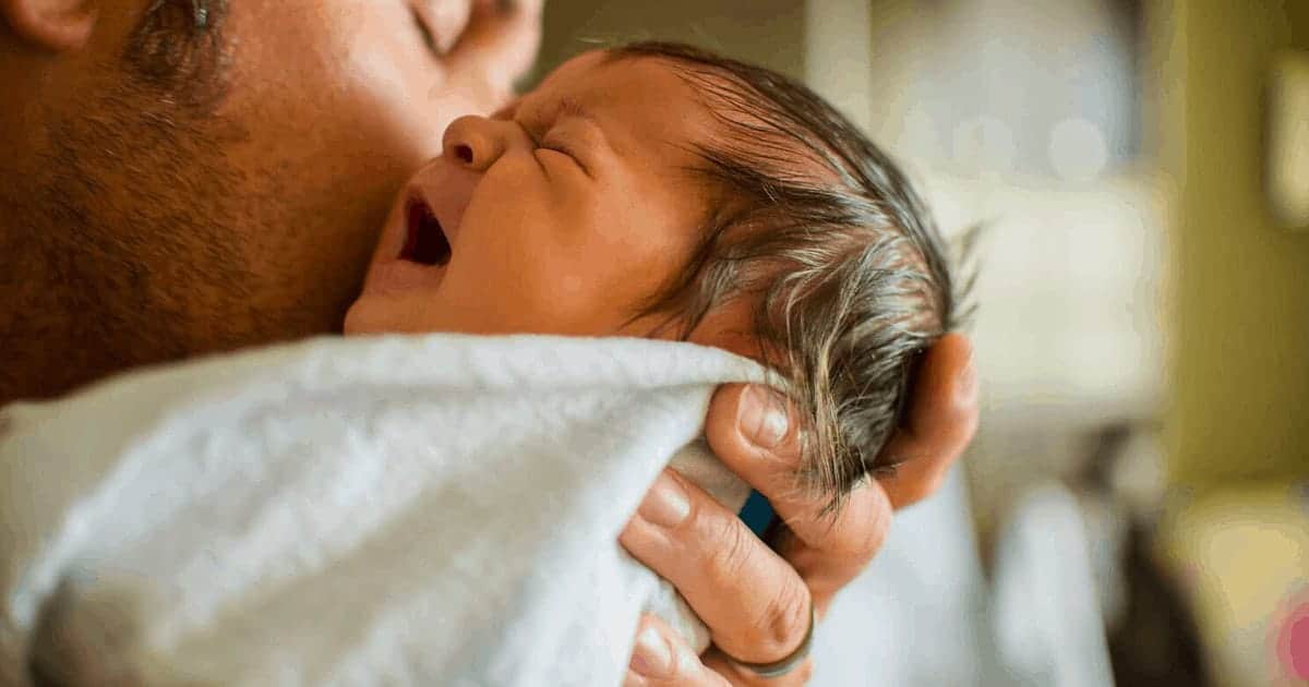 dad holding crying baby