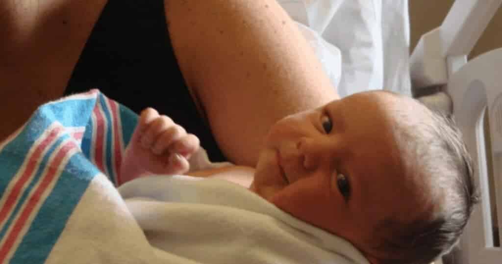 newborn baby wrapped in hospital blanket