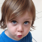 toddler looking up at mother with blue eyes