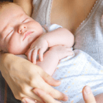 sleepy baby held by mother