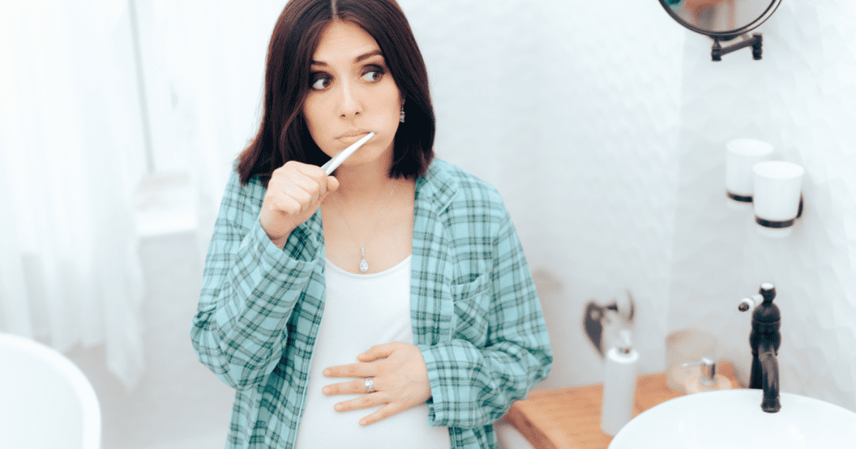 pregnant woman brushing teeth
