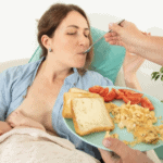 new mom eating healthy meal postpartum while baby breastfeeds