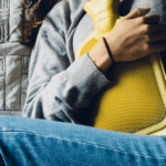 Holding a Hot Water Bottle on her abdomen