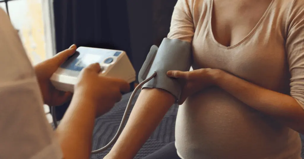taking blood pressure of a pregnant mother, monitoring for preeclampsia