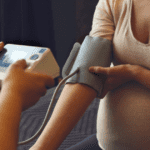 taking blood pressure of a pregnant mother monitoring for preeclampsia