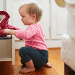 baby playing in a drawer in the bedroom