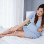 Pregnant women holding leg in pain