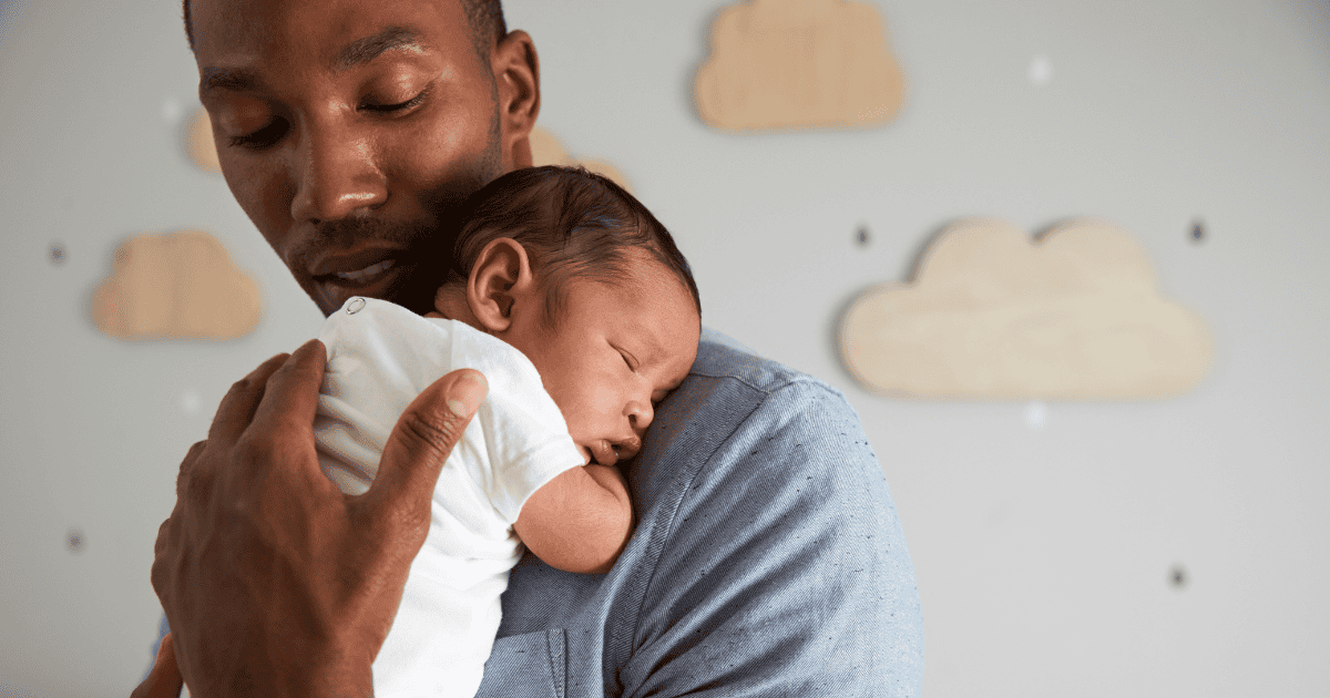 Dad holding newborn baby sleeping