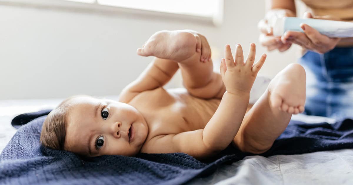 mom putting ointment on baby bottom as diaper rash treatment
