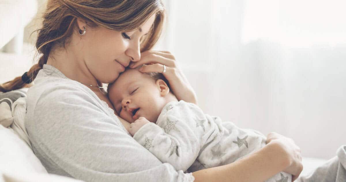 New mom holding baby on chest at home