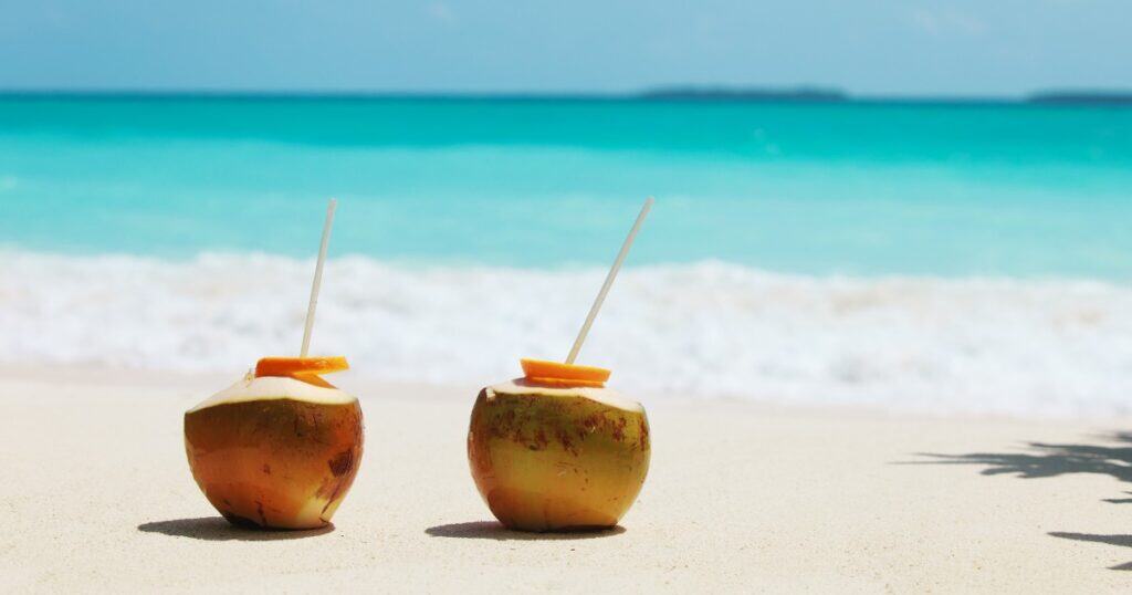 Coconuts on beach with straws