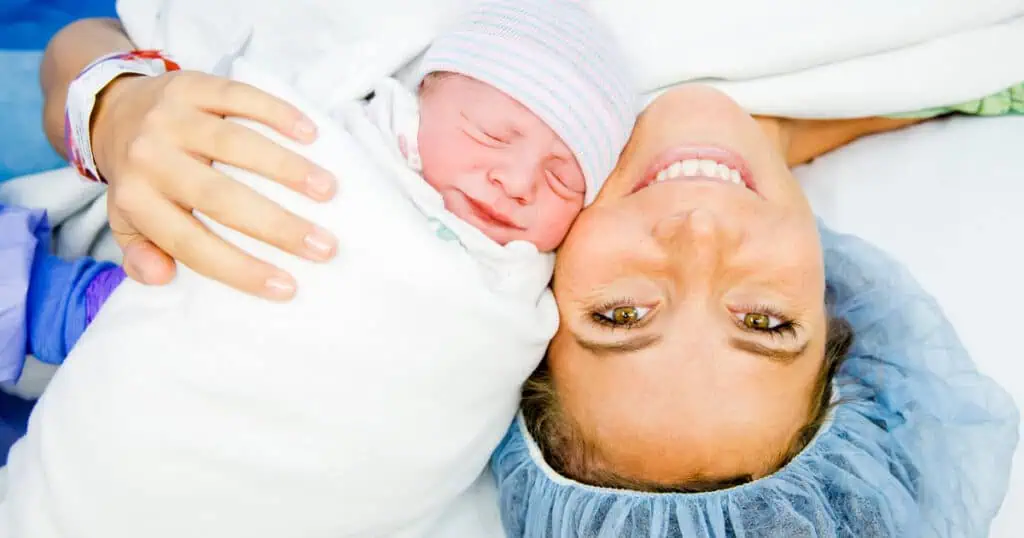 Mom having a C-Section holding her baby in the operating room, Do I need a Doula for a C-Section