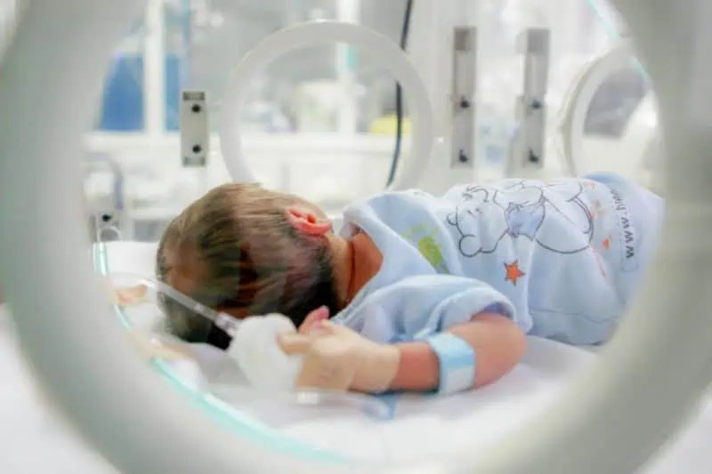 baby in NICU incubator