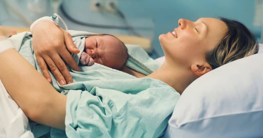 happy mom after vbac with baby on chest