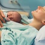 happy mom after vbac with baby on chest