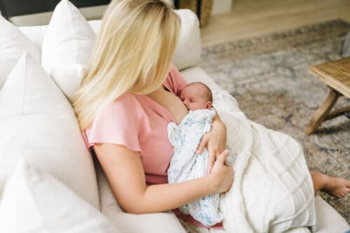New mom in Tampa FL breastfeeding on couch at home