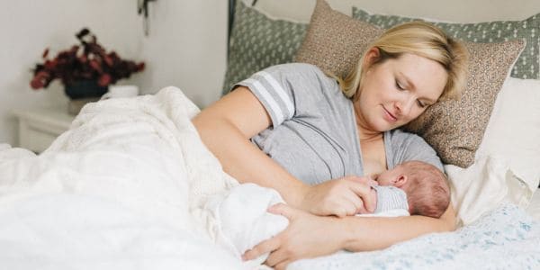 new mom breastfeeding in bed at home in Tampa FL