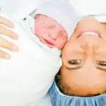 mom in or after c-section with her baby swaddled