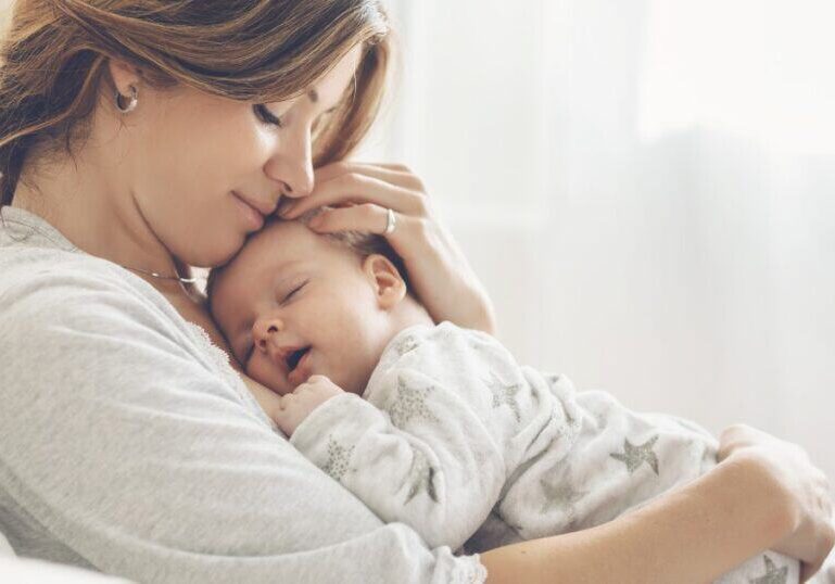 New mom holding baby on chest at home