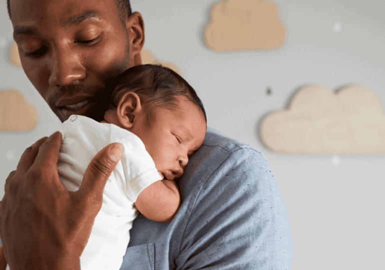 Dad holding newborn baby sleeping