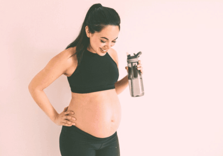 pregnant mom after workout, drinking water