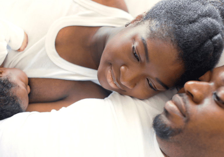 postpartum couple snuggling and breastfeeding