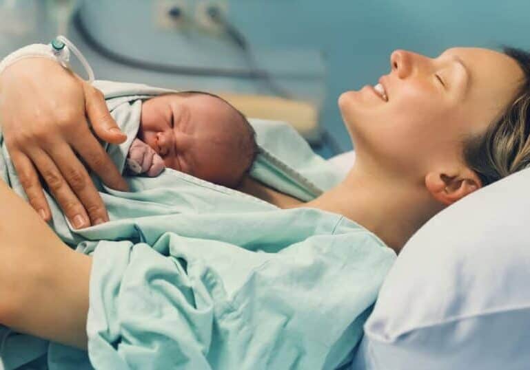 happy mom after vbac with baby on chest