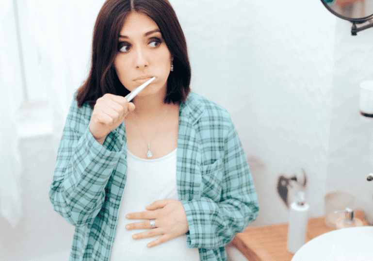 pregnant woman brushing teeth