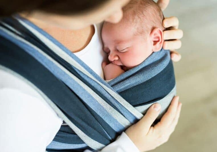 doula holding baby in sling wrap
