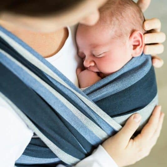 doula holding baby in sling wrap