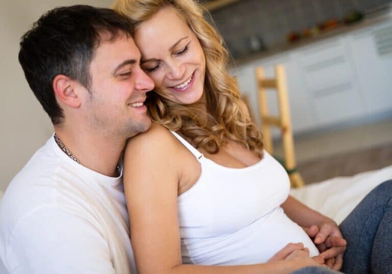 Pregnant Mom and husband snuggling during pregnancy