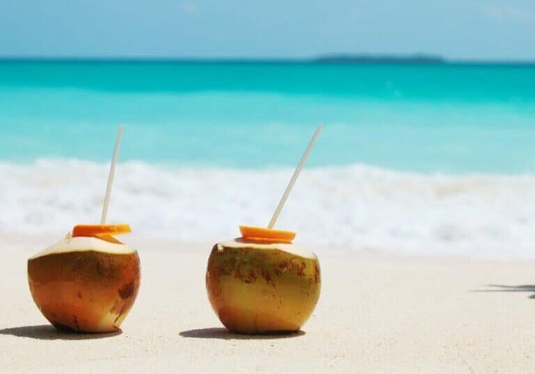 Coconuts on beach with straws