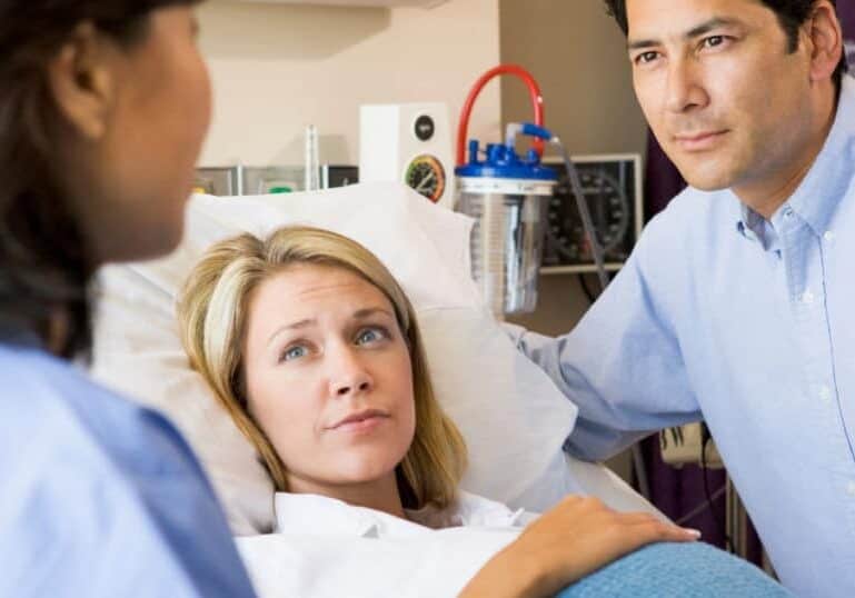 pregnant couple consulting doctor at hospital