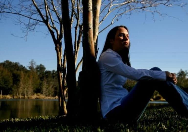 woman reflecting by pond