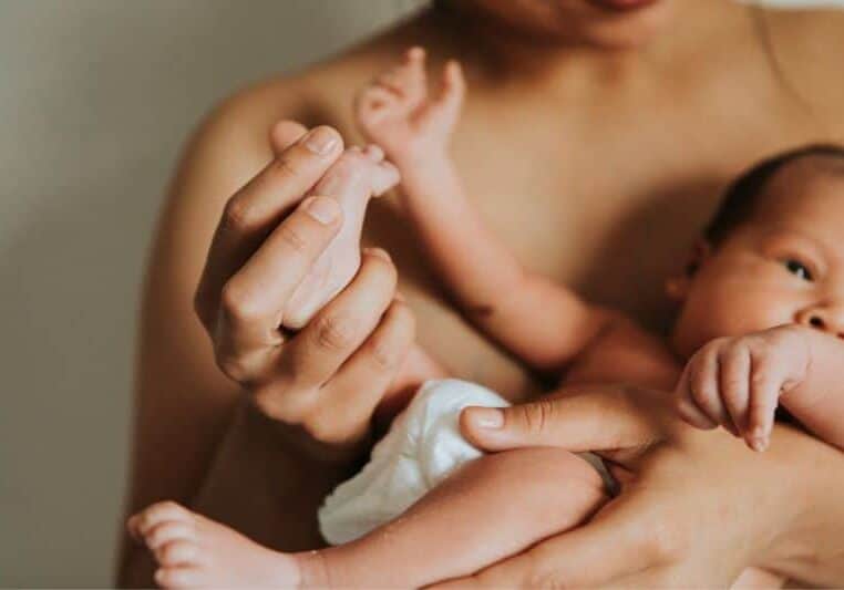 New parent holds baby skin to skin