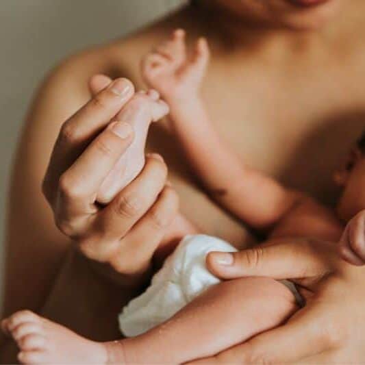 New parent holds baby skin to skin
