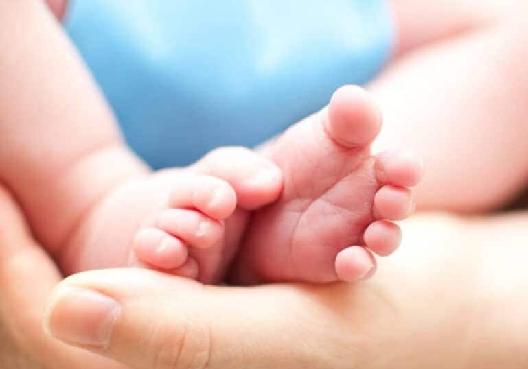 newborn feet held in hand