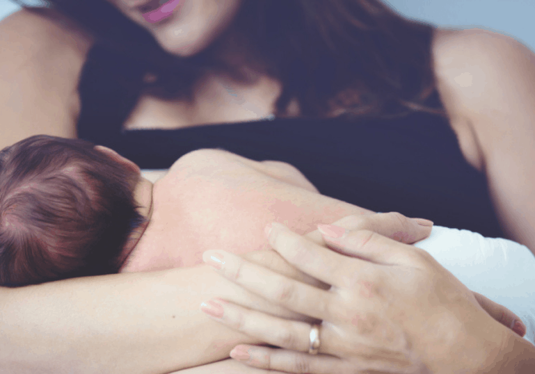 new mom breastfeeding baby in diaper