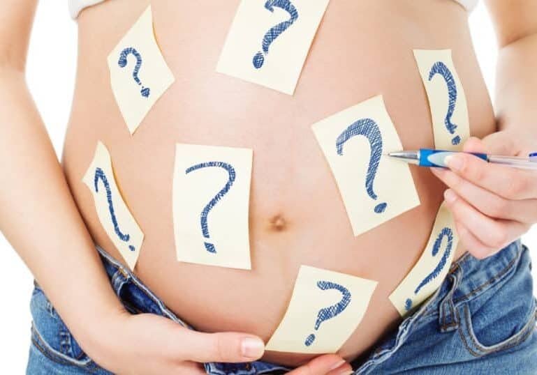 pregnant woman with question mark post its on belly