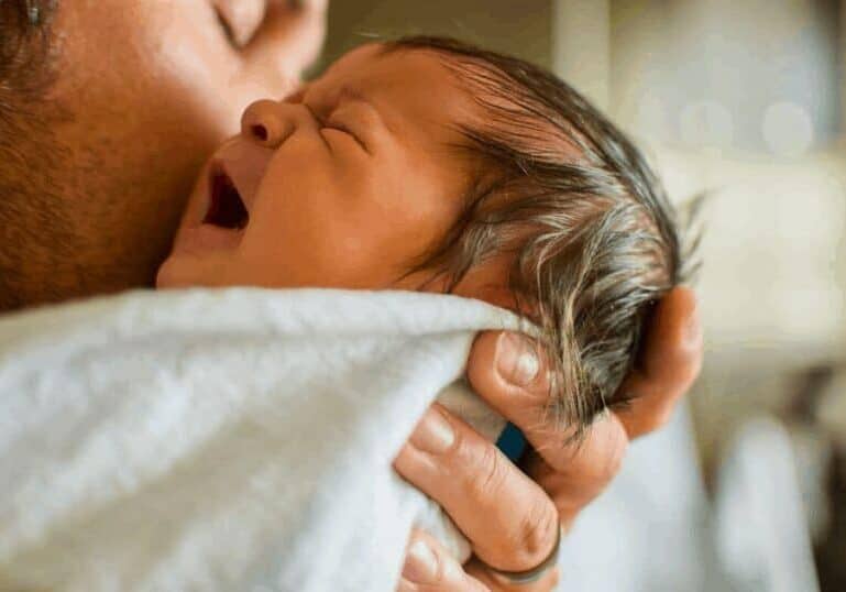 dad holding crying baby