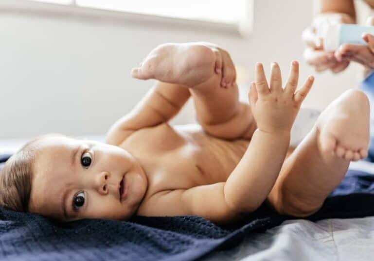 mom putting ointment on baby bottom as diaper rash treatment