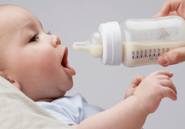 infant being fed with bottle